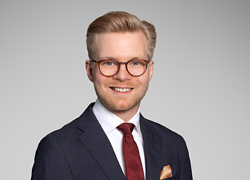 Profilbilde,mann mørk dress, lyst hår og briller