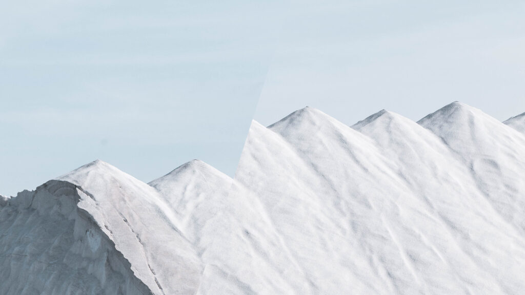 Snø og islagt fjellkjede med lys blå himmel