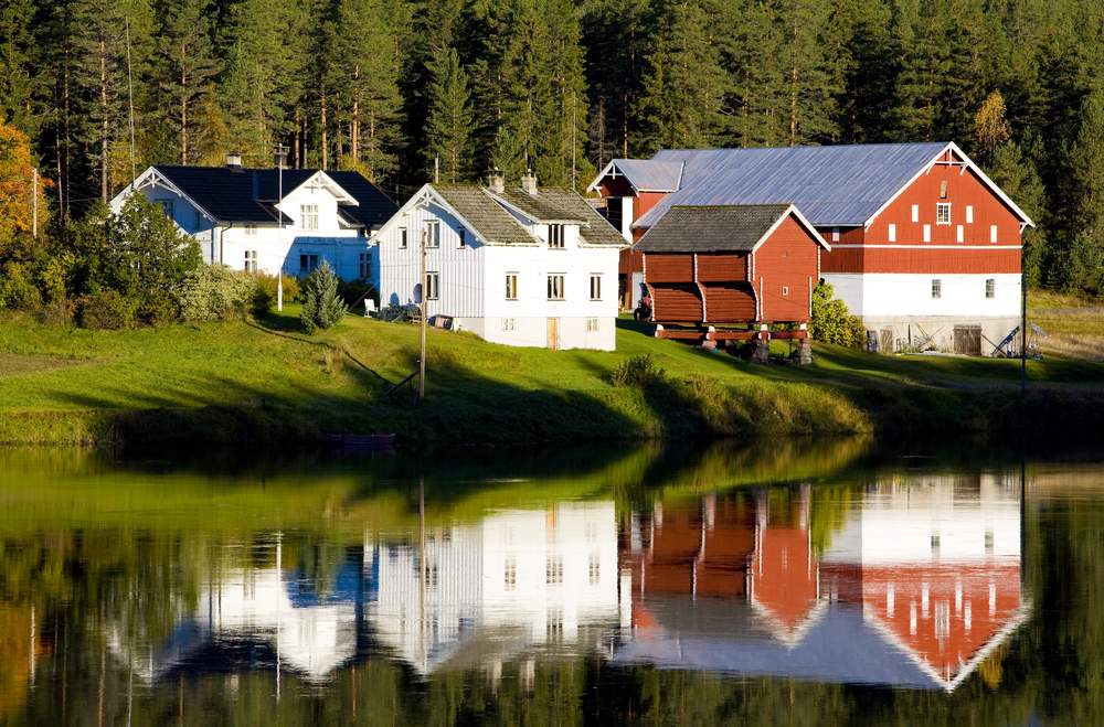 Gårdsbruk med hvit kårbolig og tilhørende gårdshus
