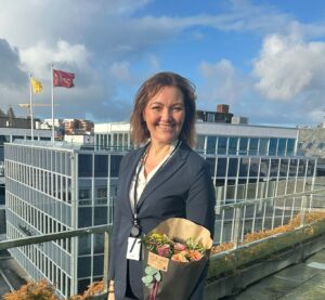 Kvinne på takterrasse med blomster i armen