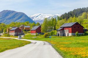 Gårdstun med røde låver langs landevei
