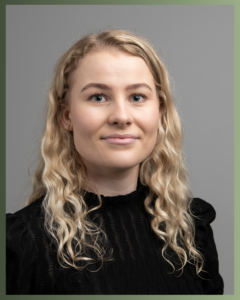 Ung kvinne kledd i sort med lyst krøllete hår